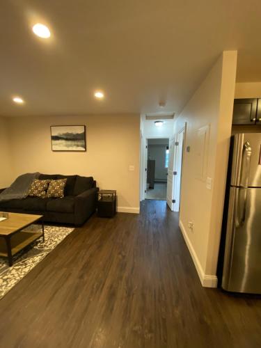 a living room with a couch and a refrigerator at Beautiful 2 bedroom 1 bath apartment with private garage in Anchorage