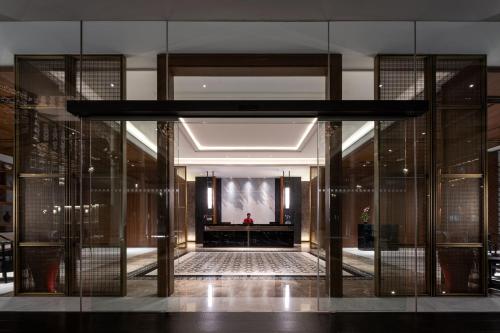 a lobby with glass doors and a stage in a building at Ramada Plaza by Wyndham Chao Fah Phuket in Phuket Town