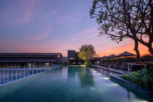 una piscina infinita al atardecer en un complejo en Ramada Plaza by Wyndham Chao Fah Phuket, en Phuket