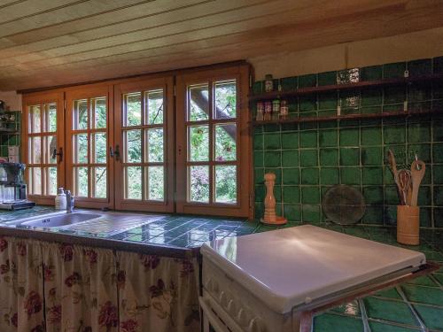- une cuisine avec un évier et du carrelage vert dans l'établissement Family house in a fairytale hamlet with a beautiful swimming pool, à Falcou