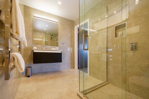 a bathroom with a glass shower and a sink at Atea Lodge in Coromandel Town