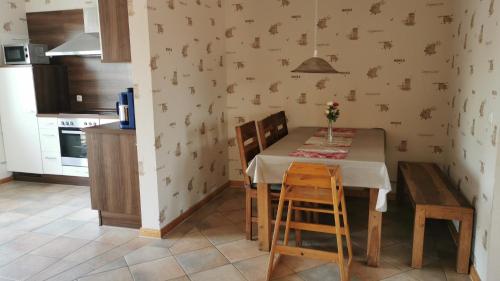 een keuken met een tafel en twee stoelen en een tafel en een keuken met bij Ferienhof Stobbe Fewo Heuboden in Grube