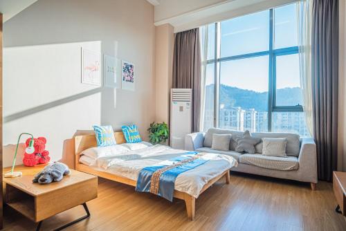 a bedroom with a bed and a couch in it at July Apartment in Hangzhou
