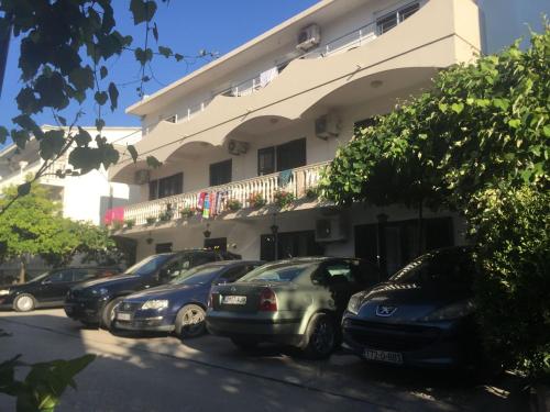 una fila de autos estacionados frente a un edificio en Family Rooms, en Ulcinj