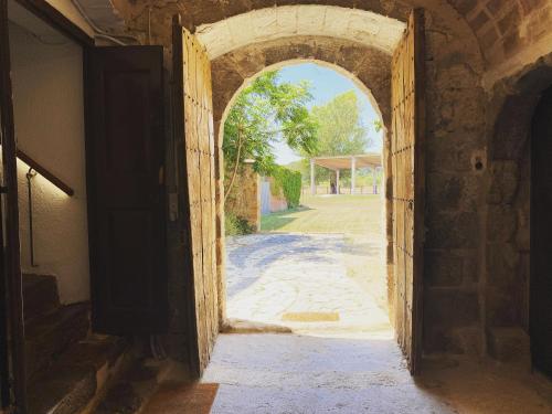 an archway leading to an entrance to a building at Cal Robusto, Apartament in Masía with horses in Siurana
