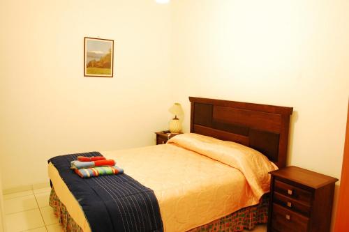 a bedroom with a bed and a nightstand and a bed sidx sidx sidx sidx at Hostal Portales in Arica