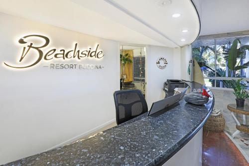 a reception desk with a laptop on a counter at Beachside Resort Kawana Waters in Buddina