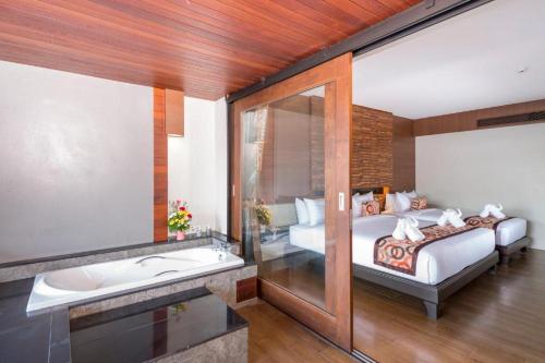 a bedroom with a bed and a bath tub and a bed sidx sidx sidx sidx at Am Samui Palace in Lamai