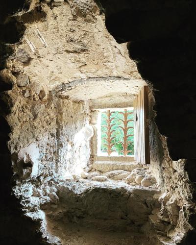 a view of a window in a stone building at Cal Robusto, Apartament in Masía with horses in Siurana