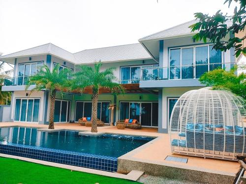 a house with a swimming pool and a bird cage at บรรเจิด วิลล่า บีช@สิชล in Ban Plai Thon