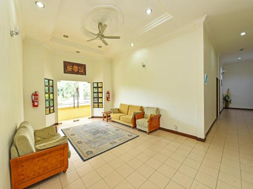 Super OYO Capital O 90434 Marmoris House في كوالا ترغكانو: غرفة معيشة مع كنبتين ومروحة سقف
