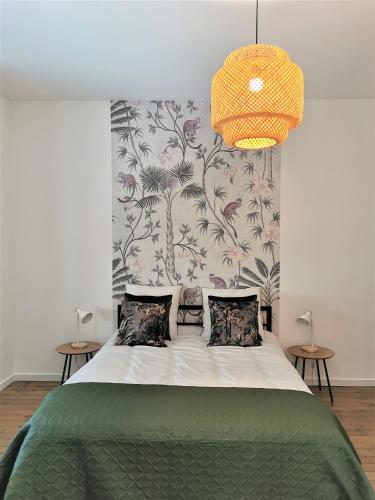 a bedroom with a large bed with a floral wallpaper at Appartement La palette in Villers-Semeuse