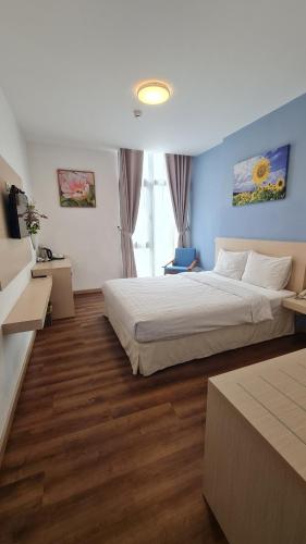 a large bedroom with two beds and wooden floors at Ngan Hoa - Mille Fleurs in Da Lat