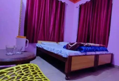 a bedroom with a bed with red curtains at Odyssey Stays Joshimath - Near Narsingh Temple in Joshīmath