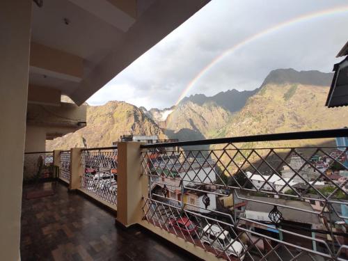 a view of a mountain range with a rainbow in the sky at Odyssey Stays Joshimath - Near Narsingh Temple in Joshīmath