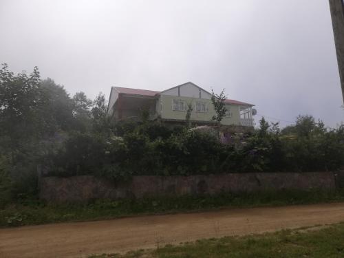 a house on top of a hill with a dirt road at Aydınlar yayla evi in Çarşıbaşı