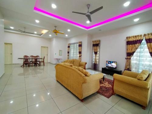 a living room with two chairs and a tv at D' Anjung Inn in Tangkak