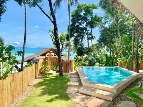 a backyard with a swimming pool and a fence at Kalulushi Bungalows in Haad Pleayleam