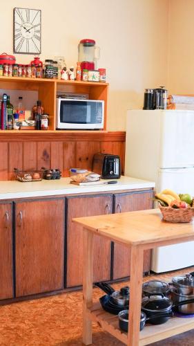 a kitchen with a table and a microwave and a refrigerator at Room @ 88 in Devonport