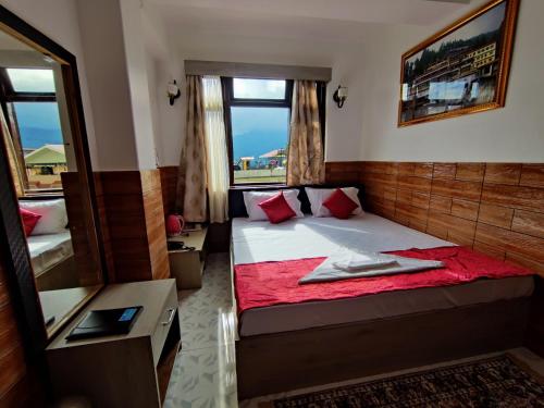 a small bedroom with a bed with a red blanket at Matina Regency in Gangtok
