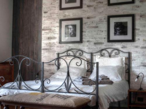 - une chambre avec un lit en métal et un mur en briques dans l'établissement Sarkeep, à Luogosano