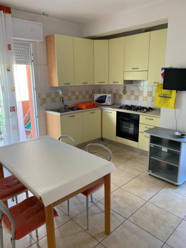 una cucina con tavolo, tavolo e sedie di Via Modena a Cattolica