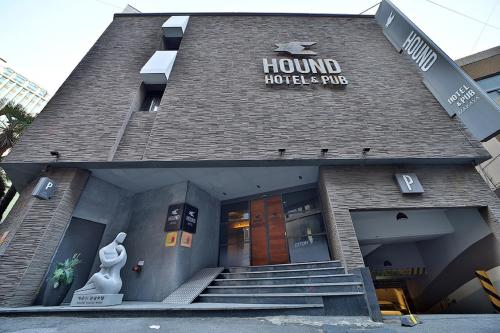 a hotel building with a front entrance with a statue at Seomyeon Hound Hotel 1st Street in Busan