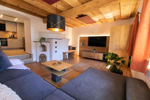 a living room with a blue couch and a table at Weisses Lamm in Hallstatt