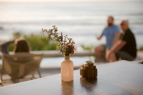 a vase with flowers in it sitting on a table at The Oystercatchers Haven at Paternoster in Paternoster