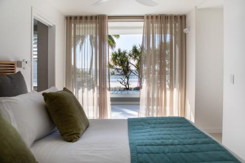 1 dormitorio con 1 cama y vistas al océano en Netanya Noosa Beachfront Resort en Noosa Heads