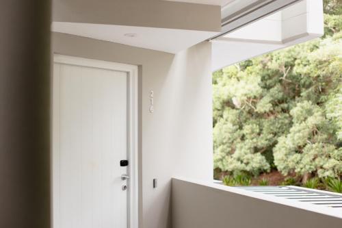 a white door in a room with a window at Netanya Noosa Beachfront Resort in Noosa Heads
