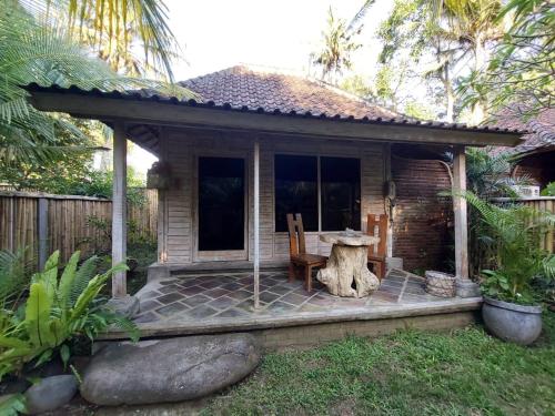 Cabaña pequeña con mesa y silla en Segara Urip, en Negara