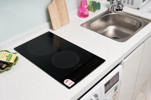 Una encimera de cocina con fregadero y microondas. en Sweet Stay, en Seúl