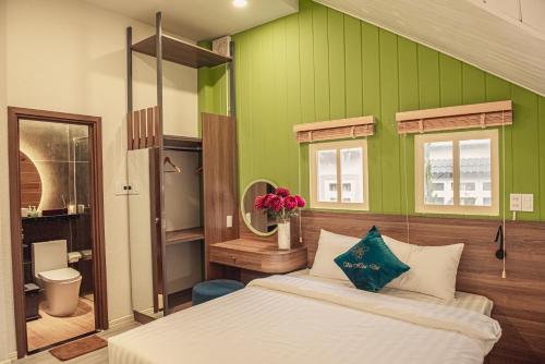 1 dormitorio con cama y pared verde en Villa Hoa Da, en Da Lat