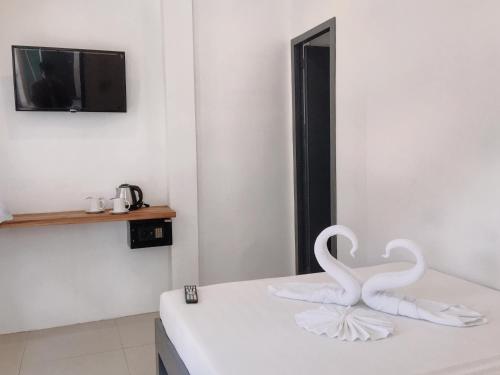 dos cisnes blancos sentados en un mostrador en una habitación en Palmera El Nido Inn, en El Nido