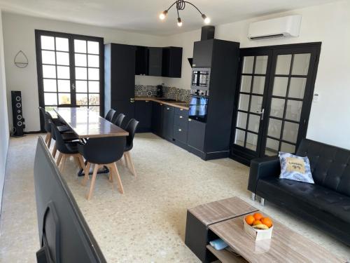 une cuisine et un salon avec une table et un canapé dans l'établissement Piscine chauffée Clim WIFI 13 personnes Centre Valras-Plage, à Valras-Plage