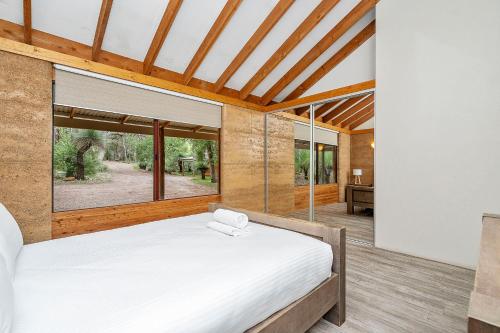 a bedroom with a bed and a large window at Possum Cottage - Woodstone Estate in Dunsborough