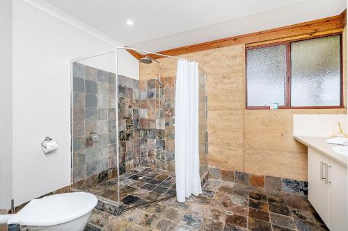 a bathroom with a shower and a toilet at Possum Cottage - Woodstone Estate in Dunsborough