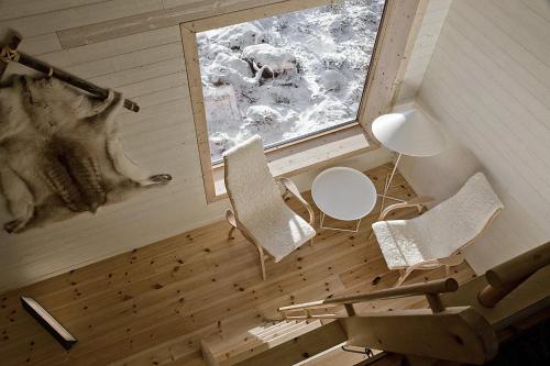 a white dog sitting in a bathroom next to a window at Treehotel in Harads