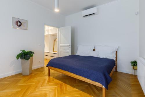 - une chambre avec un lit et une couverture bleue dans l'établissement Óváros Residence, à Veszprém