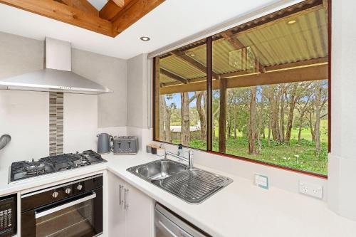 a kitchen with a sink and a window at Grasstree Cottage - Woodstone Estate in Dunsborough