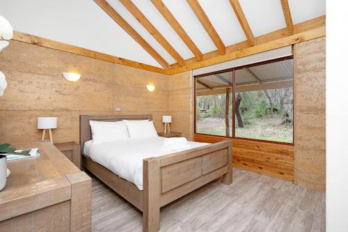 a bedroom with a bed and a large window at Grasstree Cottage - Woodstone Estate in Dunsborough