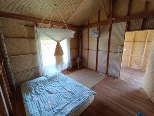 an empty room with a bed and a window at Kaewma farmstay in Ban Khuang Kom