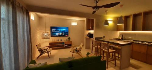 MANGLITO MANILA في لاباز: غرفة معيشة مع أريكة ومطبخ مع تلفزيون