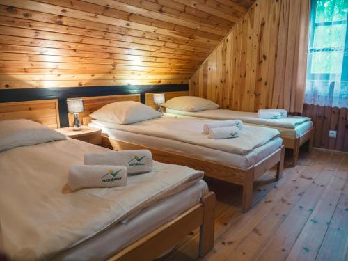 Habitación con 3 camas en una cabaña de madera en Półwysep Natura Tour, en Jastarnia