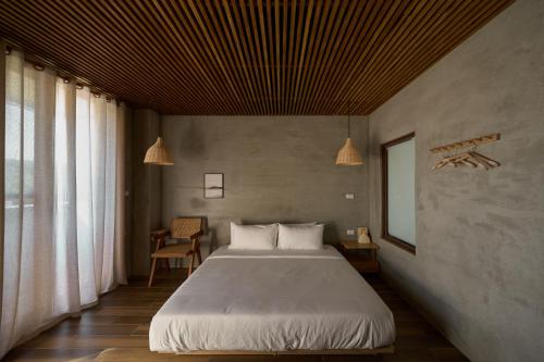 Un dormitorio con una gran cama blanca y una ventana en Seaside Snooze en Xiaoliuqiu