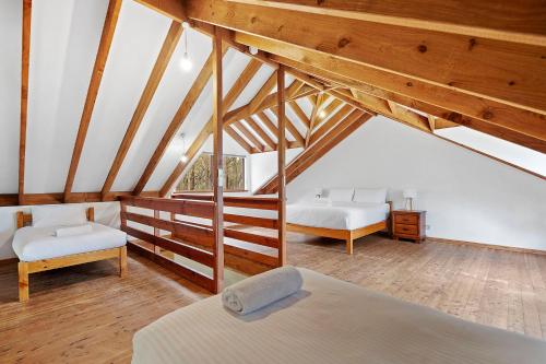 ダンズボローにあるKookaburra Cottage at Woodstone Estateの木製の天井が特徴の屋根裏のベッドルーム1室(ベッド2台付)