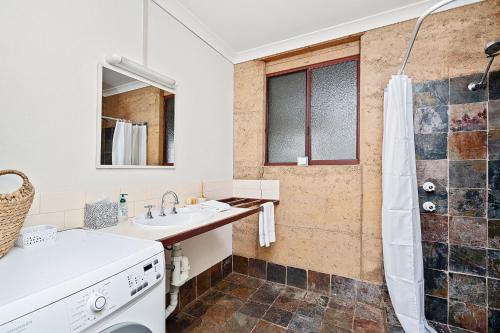a bathroom with a sink and a shower at Kookaburra Cottage at Woodstone Estate in Dunsborough