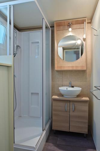 une salle de bain avec un lavabo, une douche et un miroir dans l'établissement CAMPING LES ILOTS D'OR, à Porto-Vecchio