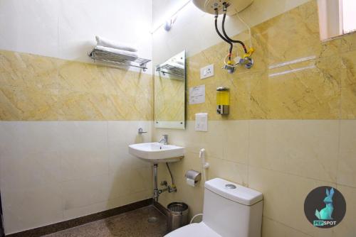 a bathroom with a toilet and a sink at The Starling BnB in Greater Noida